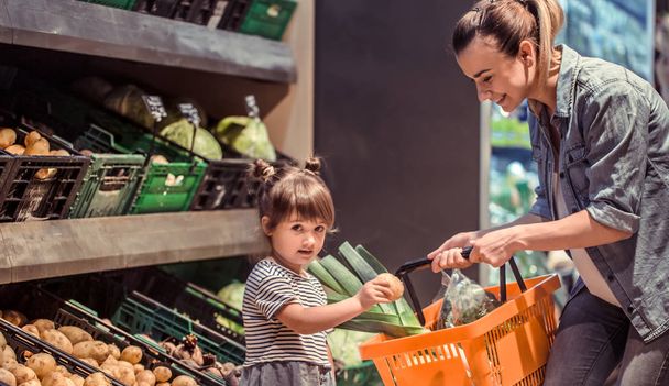 Mamma e figlia stanno facendo shopping al supermercato, il concetto di relazioni familiari e mangiare sano
 - Foto, immagini