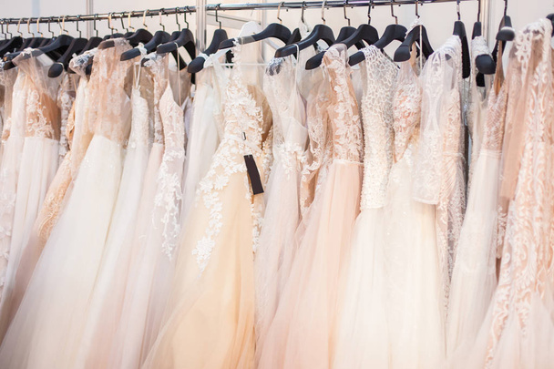 Wiele eleganckie wesele Suknie w salonie ślubu. - Zdjęcie, obraz