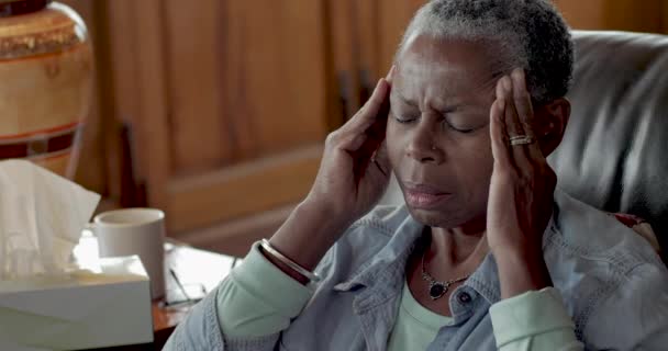 Senior czarne baby boomer pocieranie jej świątynie do łagodzenia bólu głowy - Materiał filmowy, wideo