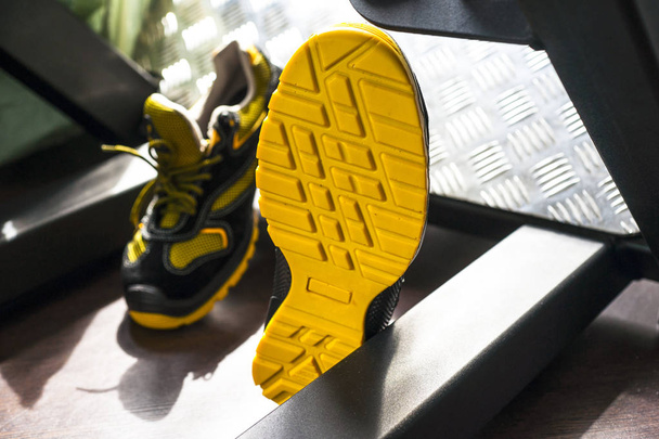 Spor salonunda UNBRANDED modern spor ayakkabı. Siyah-Sarı. Rahat ayakkabılar. - Fotoğraf, Görsel