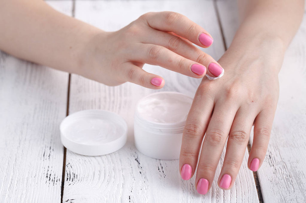 Closeup shot of hands applying moisturizer. Beauty woman holding a glass jar of skin cream - Foto, Imagem