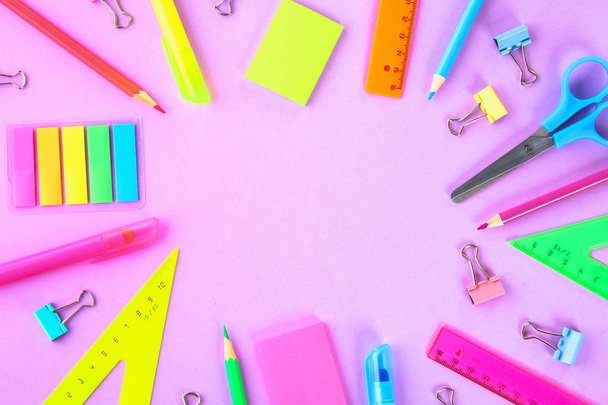 School supplies on violet background ready for your design. Flat lay. Top view. Copy space - 写真・画像