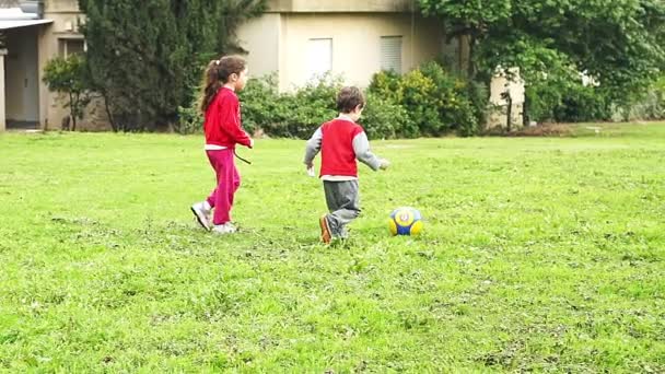 Dos niños jugando con una pelota en cámara lenta al aire libre
 - Metraje, vídeo