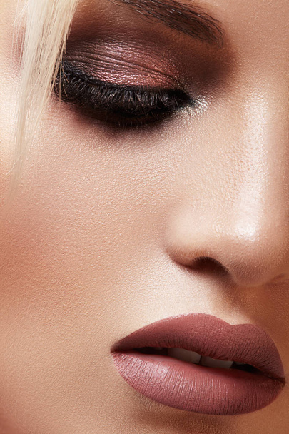 Closeup portrait with of beautiful woman face. Fashion makeup, clean shiny skin. Makeup and cosmetic. Beauty style on model face. Blond hair style - Fotó, kép