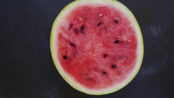 whole slice of red watermelon, rotating on black background, top view - Footage, Video