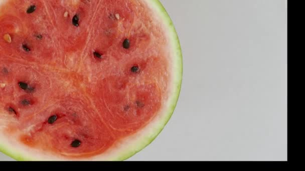celý krajíc červeného melounu, otáčení na bílém pozadí, pohled shora - Záběry, video