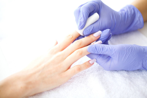 SPA manicure. French manicure at spa salon. Woman hands in a nail salon receiving a manicure procedure. Manicure procedure. - Fotó, kép