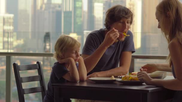Mladá rodina má na snídani, oběd na balkoně v mrakodrapu s výhledem na celé centrum města - Záběry, video