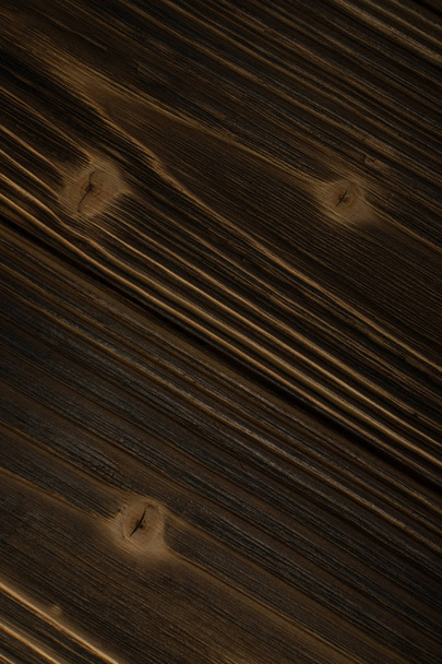 Old dark burnt wood background. Scorched wooden board plank texture. Natural rustic photo backdrop for vintage hipster design - Фото, изображение