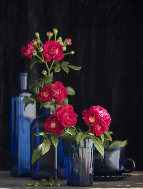 red roses in vases in dark room - Foto, Imagen