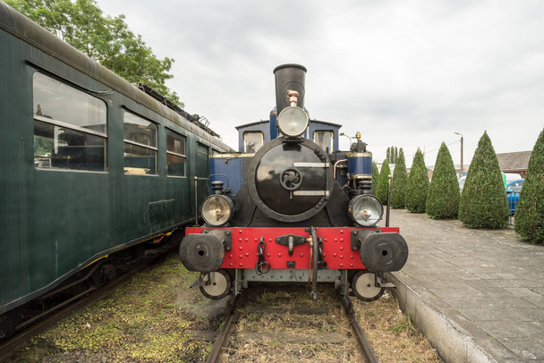 in an old train station there is an old steam train with a large oil lamp in front of his chimney - Photo, Image
