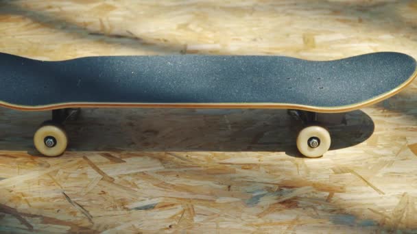 skateboard με λευκό τροχούς σε ένα ξύλινο υπόβαθρο σε ένα skatepark - Πλάνα, βίντεο