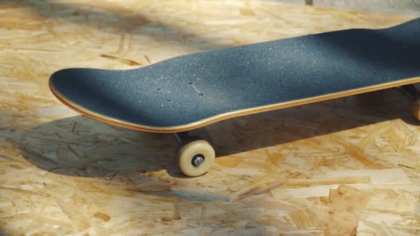 vista de un nuevo monopatín con ruedas blancas sobre un fondo de madera en un skatepark en el verano
 - Metraje, vídeo