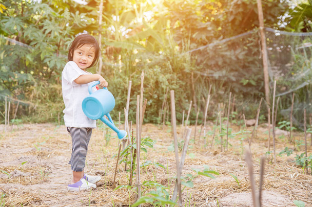 Meisje drenken boom met gieter pot - Foto, afbeelding