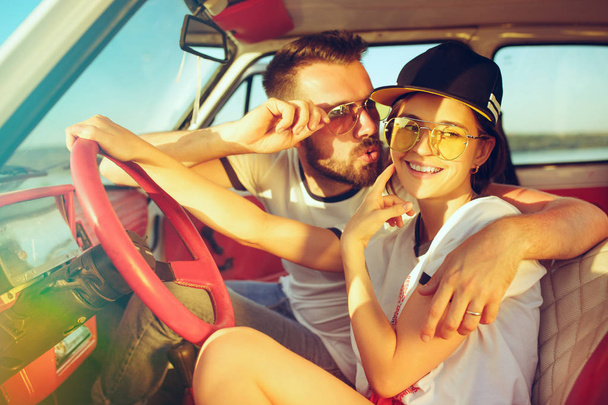 Śmiejąc się romantyczna para siedzi w samochodzie podczas się na podróż w letni dzień - Zdjęcie, obraz