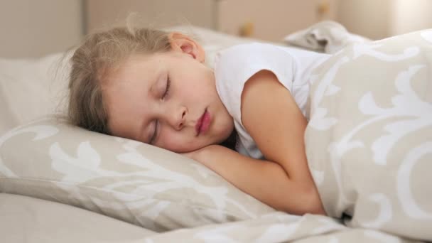Rozkošná holčička spí v posteli pohodlně v dětskej pokoj. - Záběry, video