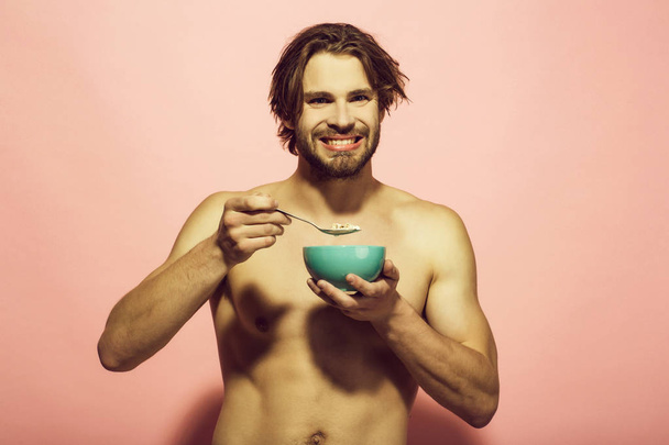Healthy food. happy muscular man eating morning breakfast - 写真・画像