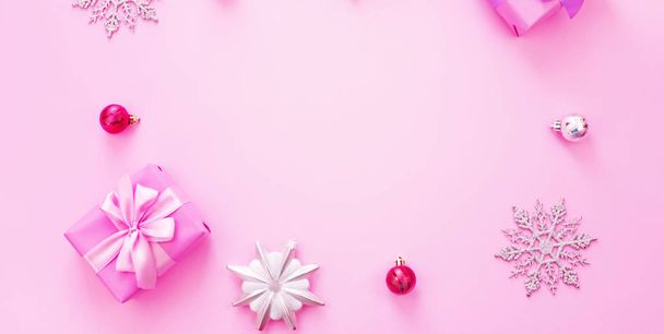 Banner Fondo decorativo Composición navideña Caja de regalo plana lazo lazo copo de nieve cóctel rosa. Espacio de copia vista superior
 - Foto, imagen
