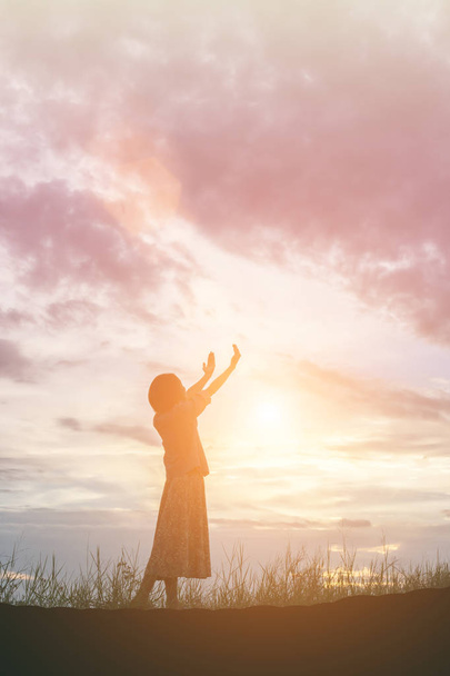 Silhouet van de vrouw bidden over prachtige lucht achtergrond - Foto, afbeelding