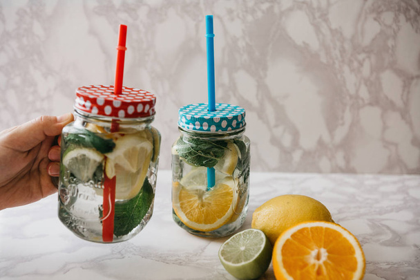 Homemade citrus lemonade or juice or mojito in a jar. Drink from citrus. - Foto, imagen