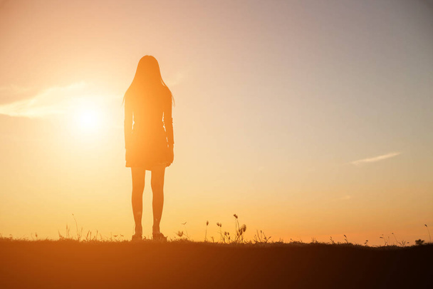 Silhouette einer betenden Frau über schönen Himmelshintergrund - Foto, Bild