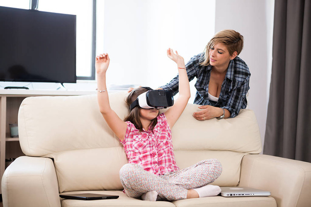 Happy kid wearing a virtual reality headset and plays games - Photo, Image
