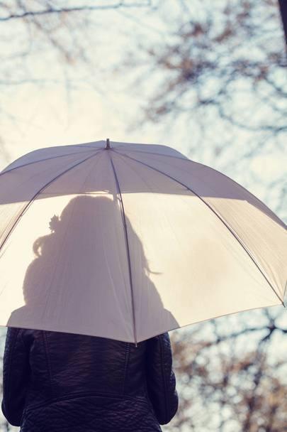 weergave vrouw met witte paraplu staande in bos terug  - Foto, afbeelding