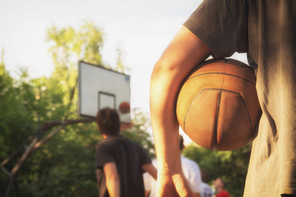 Basketball ball and player with blurred sports playground. - 写真・画像
