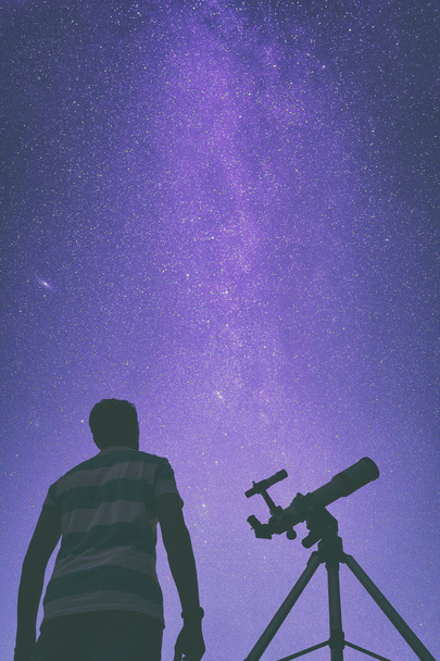 Young man using a telescope at night - Photo, Image