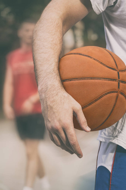 Balle de basket-ball et joueur avec aire de jeux de sport floue
. - Photo, image