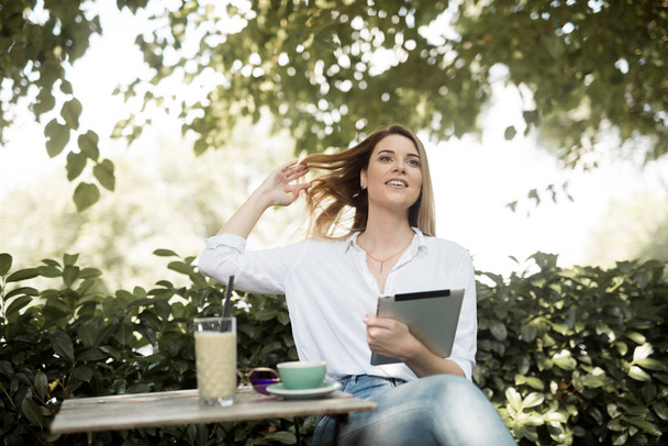 Chica en la cafetería está tomando café y el uso de la tableta
 - Foto, Imagen