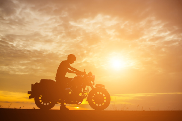 Uomo motociclista oltre il tramonto
  - Foto, immagini