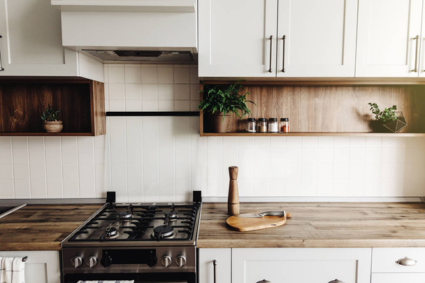 Moderní design kuchyně ve skandinávském stylu. světle šedé kuchyni stylový interiér s moderním nábytkem a nerezové spotřebiče. Dřevěná deska, ocelová kamna, Rada, nůž a koření - Fotografie, Obrázek