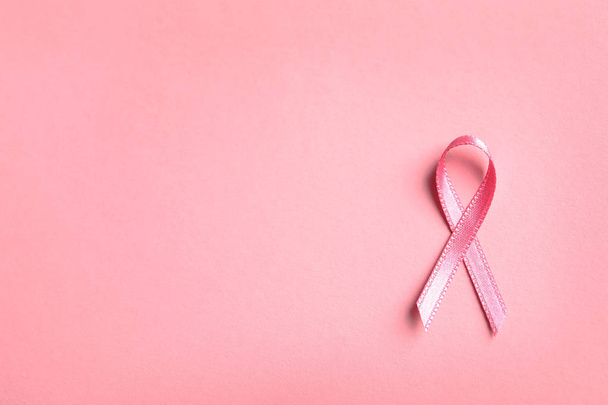 Pink ribbon on color background, top view. Cancer awareness - Foto, imagen
