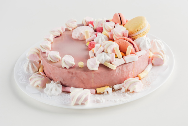 close up of pink cake with marshmallows and macarons on white plate - Fotografie, Obrázek