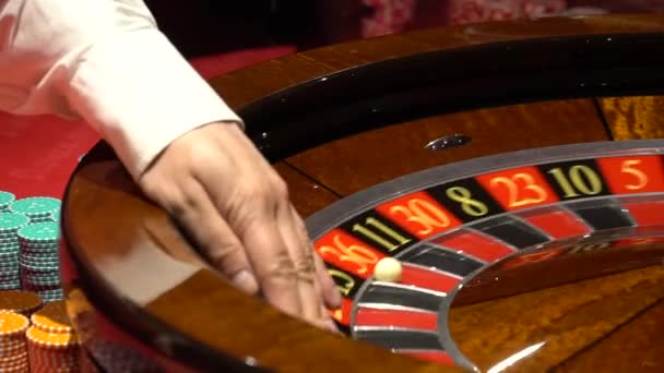 Casino roulette in beweging, spinnewiel bal en croupier hand - Video