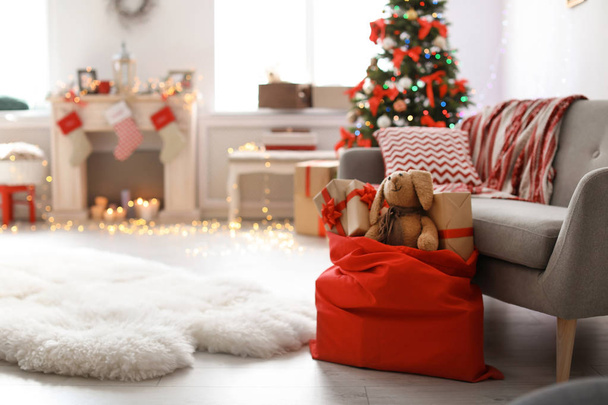 Room interior with Christmas tree and Santa's bag of gifts - Foto, afbeelding