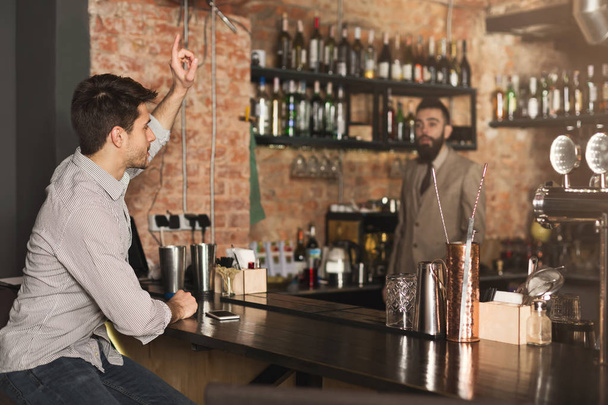 Młody człowiek jest zamawianie piwa w barze - Zdjęcie, obraz