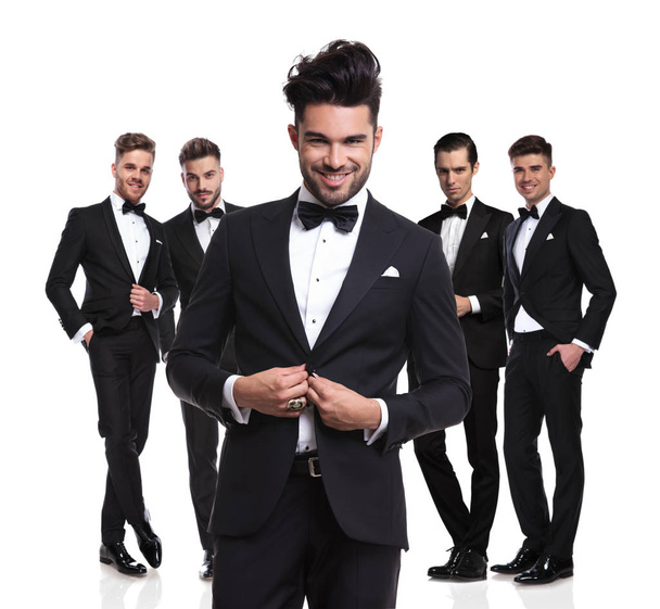 fünf attraktive elegante Männer, die auf weißem Hintergrund stehen und den Anzug vor sich zuknöpfen - Foto, Bild