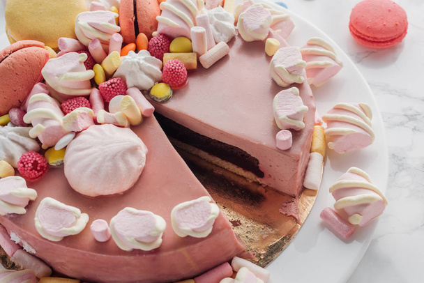 close up of pink birthday cake with marshmallows, macarons and candies - 写真・画像