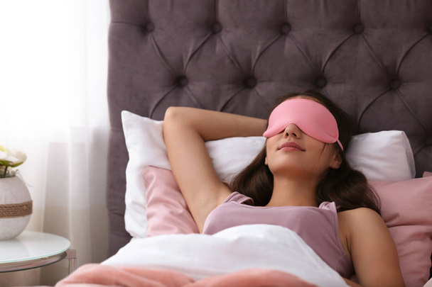 Young beautiful woman with mask sleeping in bed at home. Early morning - Foto, Imagem