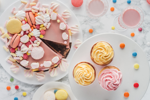 top view of birthday cake with marshmallows, cupcakes and milkshakes on table  - Фото, зображення