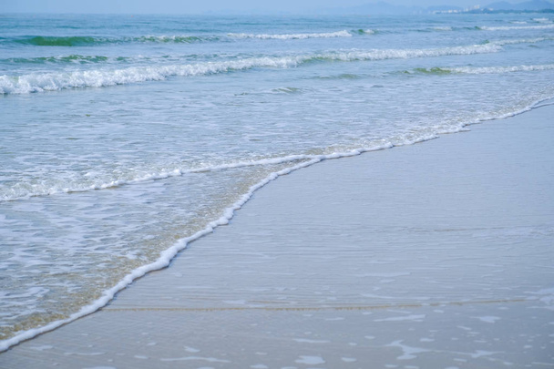 Morbida onda di oceano blu sulla spiaggia sabbiosa. Contesto. Onda del mare sulla spiaggia di sabbia
 - Foto, immagini
