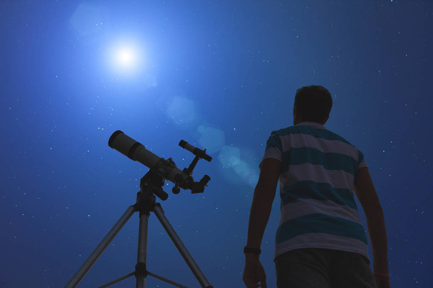 Mladý muž, pomocí dalekohledu v noci - Fotografie, Obrázek