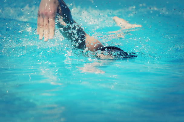 身に着けている水泳のクロールを泳ぐ運動若い男性トライアスリート ゴーグル プールの青い水の中 - 写真・画像