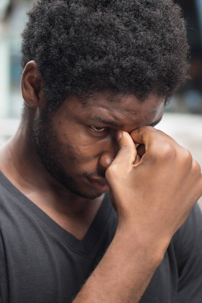 Portret van gestresste zieke Afrikaanse man met hoofdpijn; zieke Afrikaanse man of zwarte man lijdt aan hoofdpijn, vertigo, duizeligheid, migraine, stress, depressie, kater concept; volwassen Afrikaanse man model - Foto, afbeelding