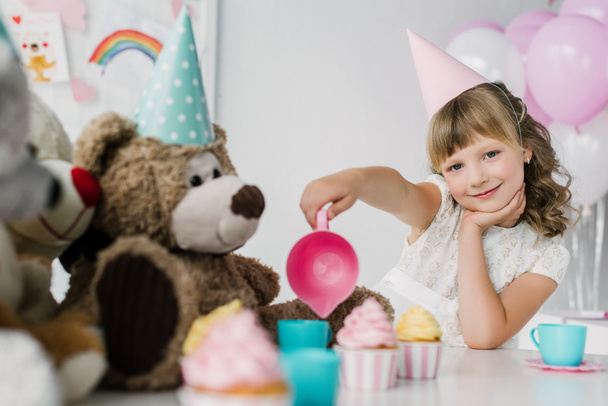 smiling birthday child having tea party with teddy bears in cones  - Photo, Image
