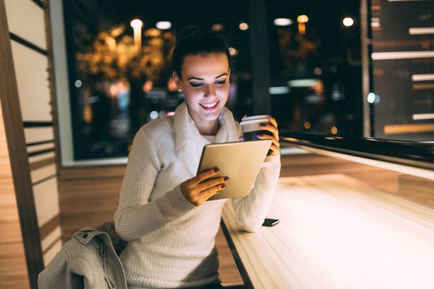 Mujer joven atractiva usando tableta digital en la cafetería
 - Foto, imagen
