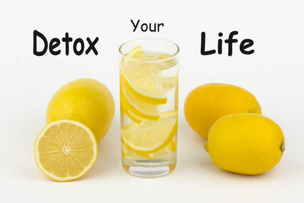 Detox Your Life escrito sobre fondo blanco y vaso de agua con rodajas de limón
. - Foto, Imagen