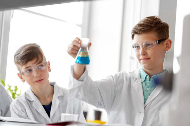 boys with test tube studying chemistry at school - Fotó, kép